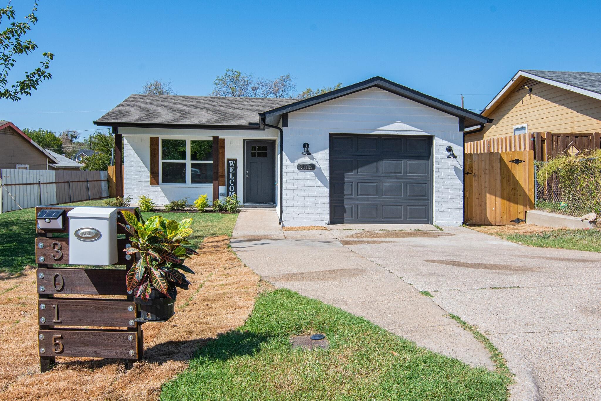 Home remodeled by Byron Haynes on Roosevelt Ave — white brick exterior with fresh landscaping