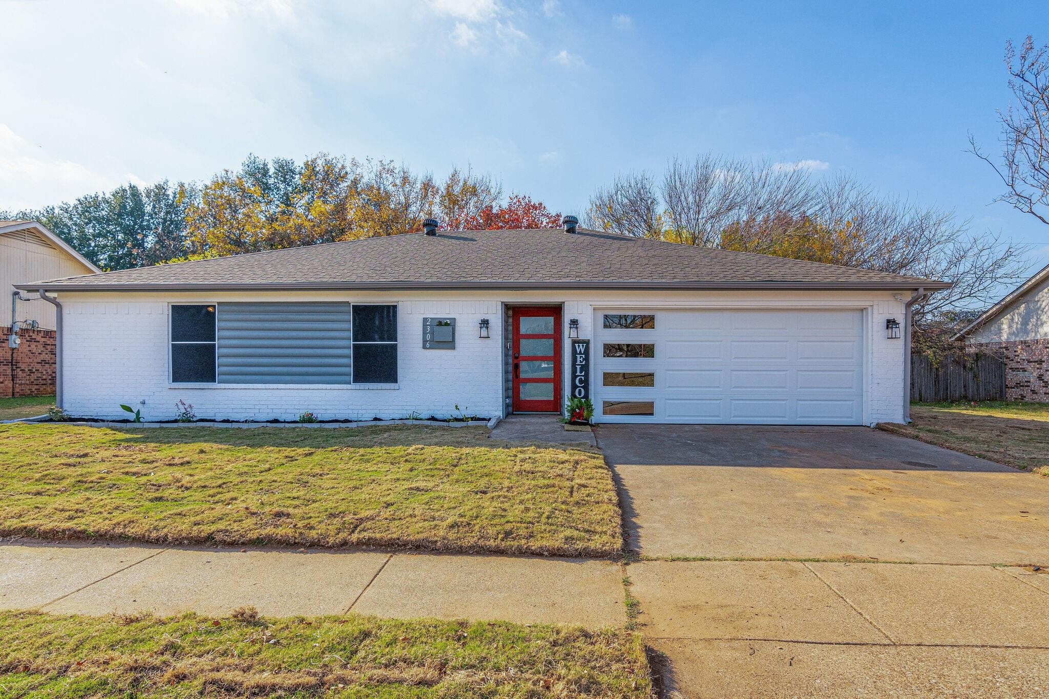 Home remodeled by Byron Haynes on Woodside — white brick with bold red front door